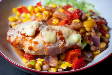 Homemade chicken and cheese enchilada bake in a bowl with a side of green lettuce