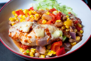 Homemade chicken and cheese enchilada bake in a bowl with a side of green lettuce