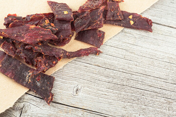 Spiced beef jerky on a wooden board. Sliced beef jerky. Dried meat.
