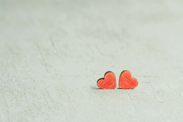 Fototapeta premium two red hearts on a blurry concrete background out of focus, the concept of Valentine's Day and March 8
