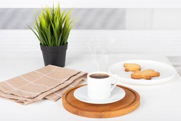 Coffee on a stand and a plate of biscuits.