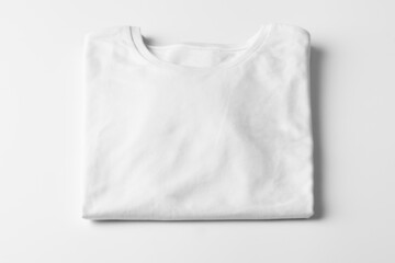 Basic folded white Tshirt on grey table. Mock up for branding t-shirt. Monochrome trend. 