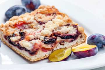 piece of plum pie with plums around
