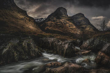 Glencoe Scotland, the three sisters and waterfalls. Dramatic stormy sky landscape photography of this iconic Scottish Highlands landmark. 
