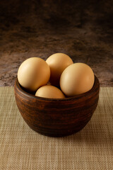 brown Easter eggs in an earthenware bowl in a rustic style