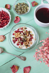 Healthy breakfast with yogurt, nuts, cereals and pomegranate seeds. Healthy snack packed with vitamins and antioxidants