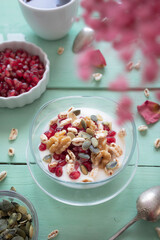 Healthy breakfast with yogurt, nuts, cereals and pomegranate seeds. Healthy snack packed with vitamins and antioxidants