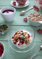 Healthy breakfast with yogurt, nuts, cereals and pomegranate seeds. Healthy snack packed with vitamins and antioxidants