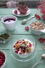 Healthy breakfast with yogurt, nuts, cereals and pomegranate seeds. Healthy snack packed with vitamins and antioxidants