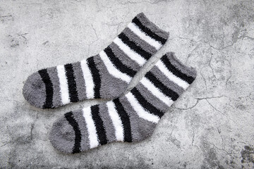 A pair of grey stripe Winter socks in a grey background.