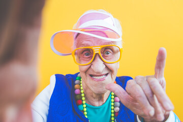 Funny grandmother portraits. 80s style outfit. trapstar taking a selfie on colored backgrounds....