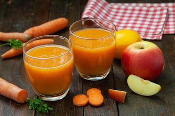 Natural organic fresh juice made of carrots and apples on wooden table. Healthy carrot, apple and...