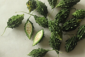 Bitter gourd, also known as pavakka or karela. Shot on white background highlighting inner flesh of...