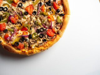 Close-up of a delicious vegetarian pizza with vegetables and mushrooms on a white background. Top view, flat lay, copy space