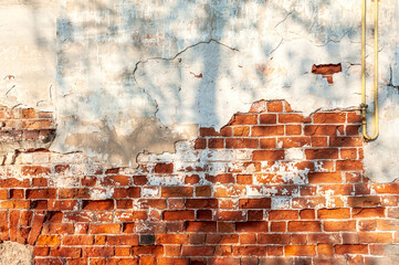 Old brick wall with peeling plaster, grunge background