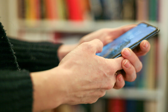 A woman holding a cell phone in her hands