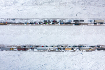Top down photo of heavy traffic on snow covered highway.