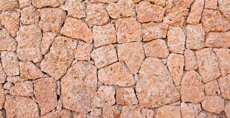 Masonry wall of stones with irregular pattern texture.