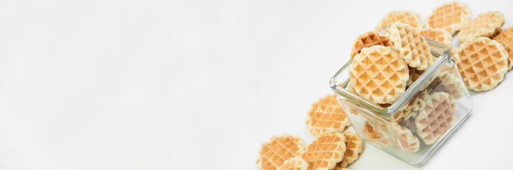 cookies in a glass jar on a white background. Belgian waffles in a bowl. fresh baking concept.
