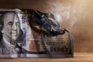 Closeup shot of burnt remainings of a one hundred dollar bill damaged in a fire