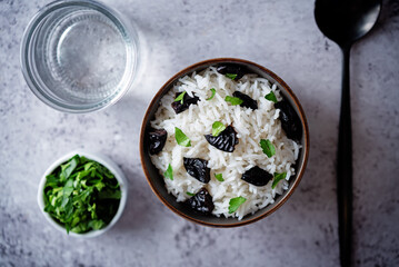 Prunes rice with parsley in a bowl