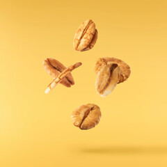 Fresh Granola flakes falling in the air on yellow background.