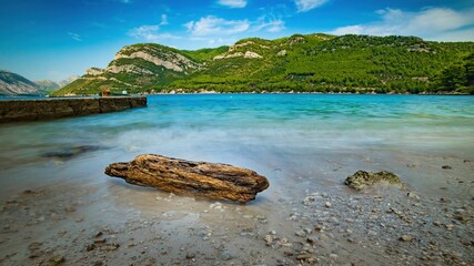 Wybrzeże i morze Chorwacji z kamienną plażą i niebieskim niebem z białymi chmurami