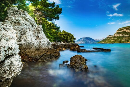 Wybrzeże i morze Chorwacji z kamienną plażą i niebieskim niebem z białymi chmurami