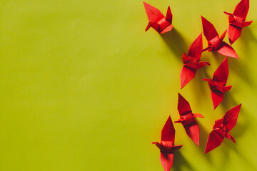 Seven red Origami Birds are flying leading by a pink bird, isolated on white,Red origami paper...