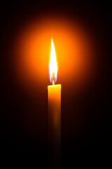 Close up single candle light and flame on black background