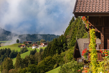 View of green meadow in mountains from typical wooden house balcony  village  on Alps, Austria.