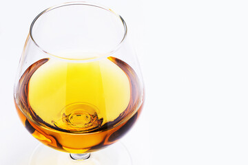 Snifter glass filled with a brandy on white background