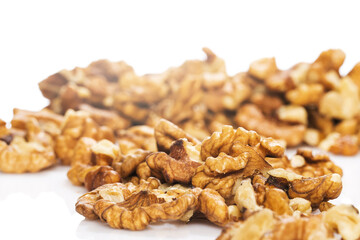 Pile of peeled walnuts on white background