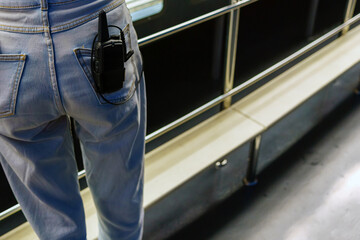 Radio station with connected intercom in the back pocket of jeans