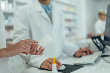 Young female pharmacist holding medications in her hand