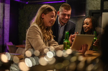 Cheerful colleagues drinking beer in the bar together after work