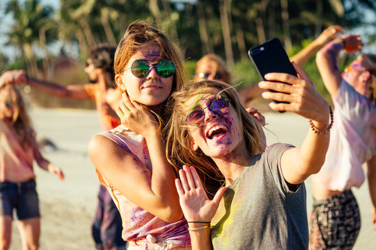 happy people taking self portraits on smartphone in India Goa fest