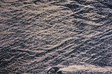 Sand on the beach with rocks. Arranged in irregular shapes under the influence of waves.