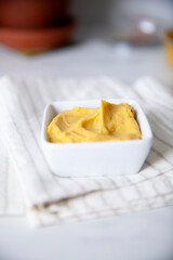 Yellow dip in a small container on a linen