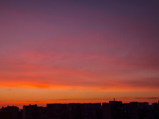 Fototapeta premium Sunset background with wonderful red,golden, yellow sky, Amazing purple and orange sky in evening during the sun going down above city.Dramatic sunset sky with clouds