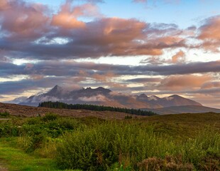 Isle of Sky Scotland highlands sunset with nice colours on the mountains in background and beautiful clouds 