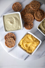 Top view of variety of dips and crackers