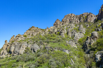 Ancient limestone high mountains of rounded shape in the air haze. The Valley of Ghosts. Demerdzhi. Crimea.