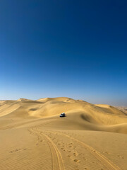 Fototapeta na wymiar Dune driving in desert. White SUV car off road travel in Africa. 