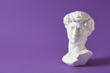bust of david replica on purple background copy space