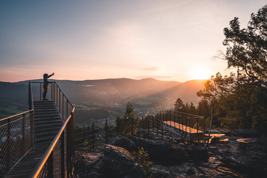 Man pointing straigt on a wonderful sunrise on new and modern lookout forest park The Guard Patrol, Czech: Straz, Sunrise on Straznik Hill above Rokytnice nad Jizerou, Giant Mountains National Park