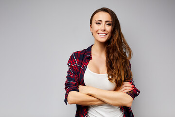 Portrait of beautiful young woman smiling looking at camera isolated on grey background