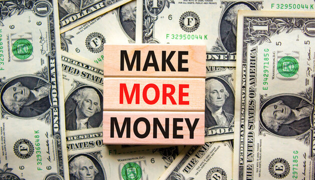 Make more money symbol. Concept words Make more money on blocks on beautiful background from dollar bills. Business, invest and make more money concept. Copy space.