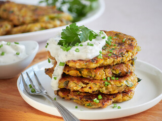 close up view of vegetarian pancakes stack, vegetable fritters, served with sour cream and fresh...
