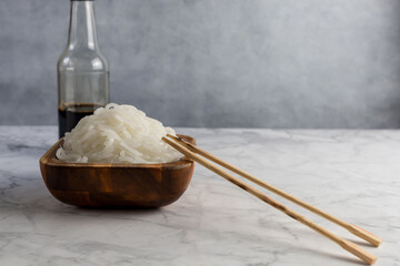 White shirataki noddle on white background with soy sauce . Konjac low carb pasta .